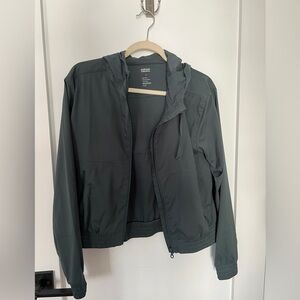 Light rain jacket with adjustable hoodie in dark green.